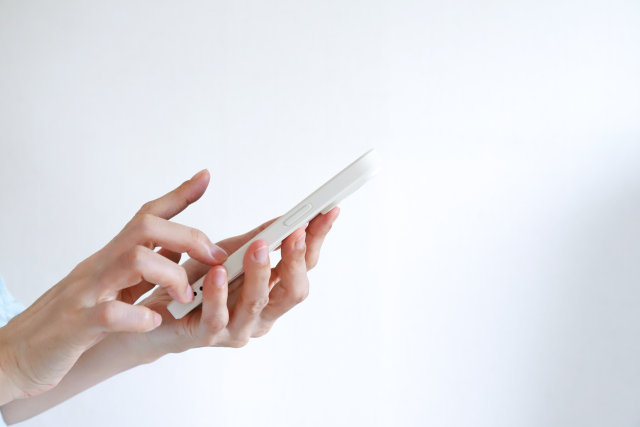 スマートフォンを操作する手元